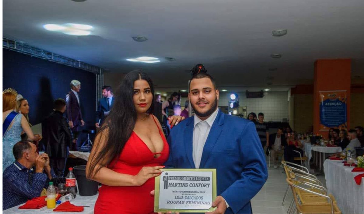 Kaio e Laury Martins recebendo a placa do Prêmio Mérito Lojista